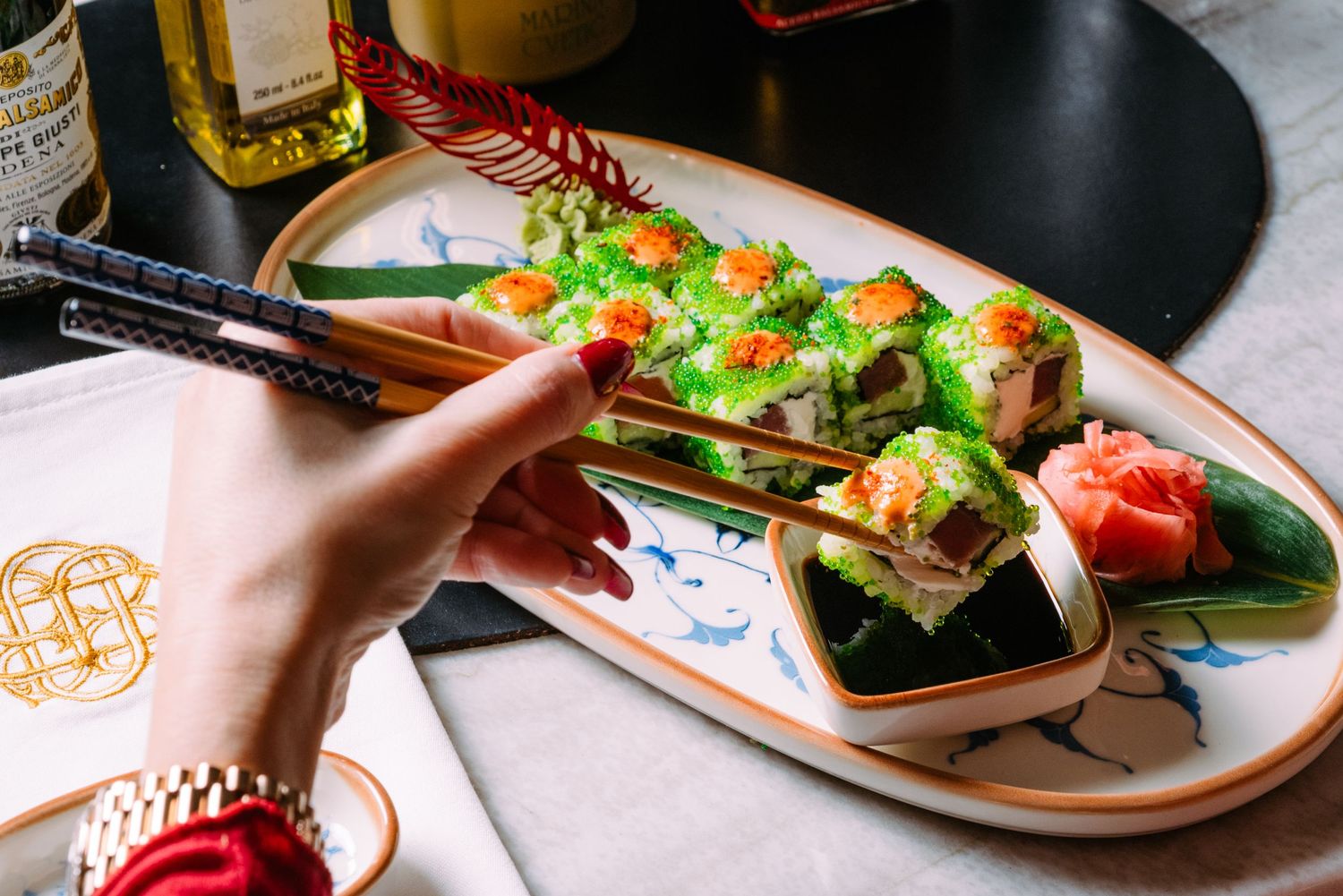 Colorful assortment of sushi rolls and Japanese dishes artfully plated on ceramic dishes at a restaurant.