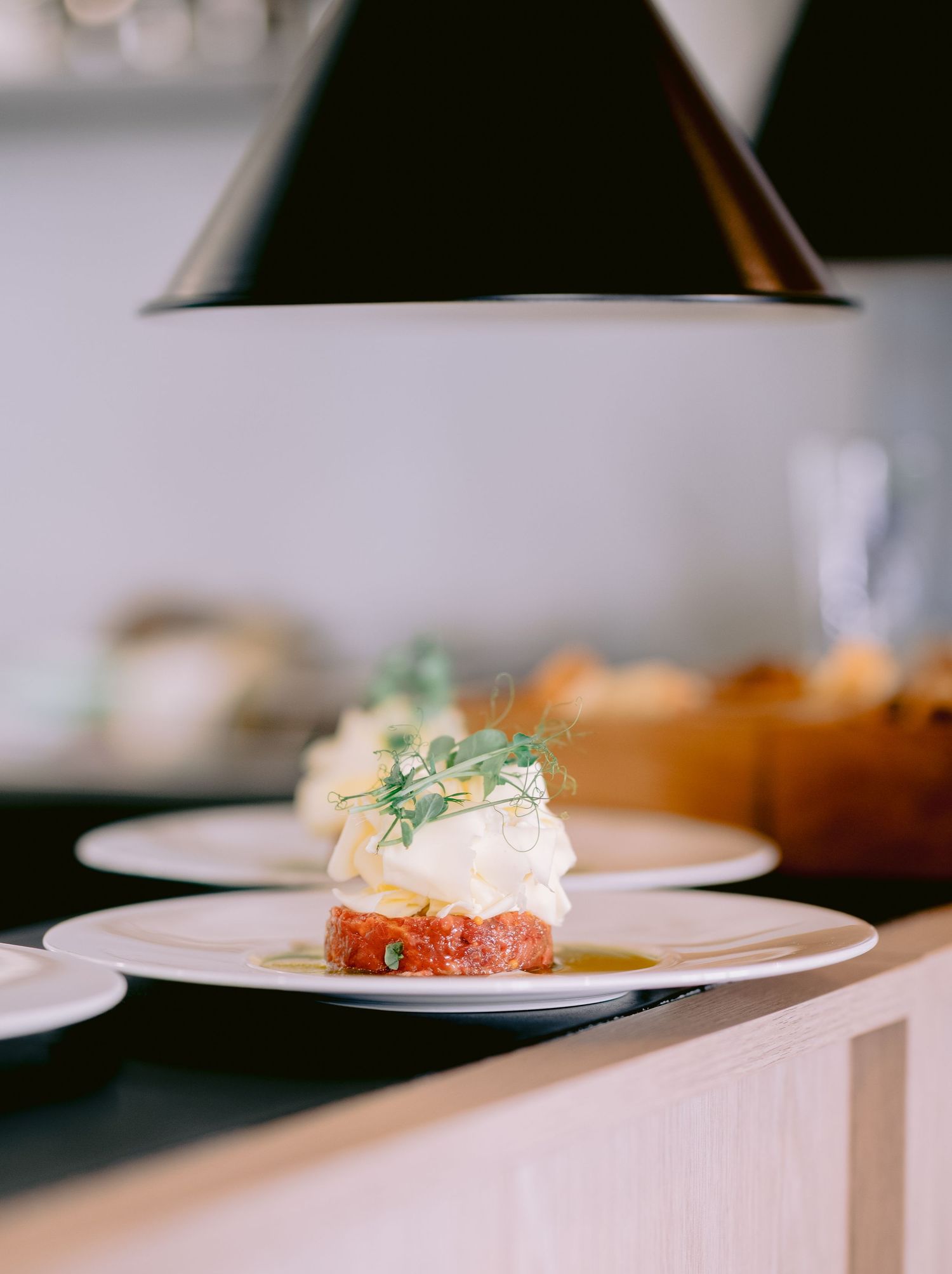 Elegant plated appetizer with microgreens on white ceramic dish.