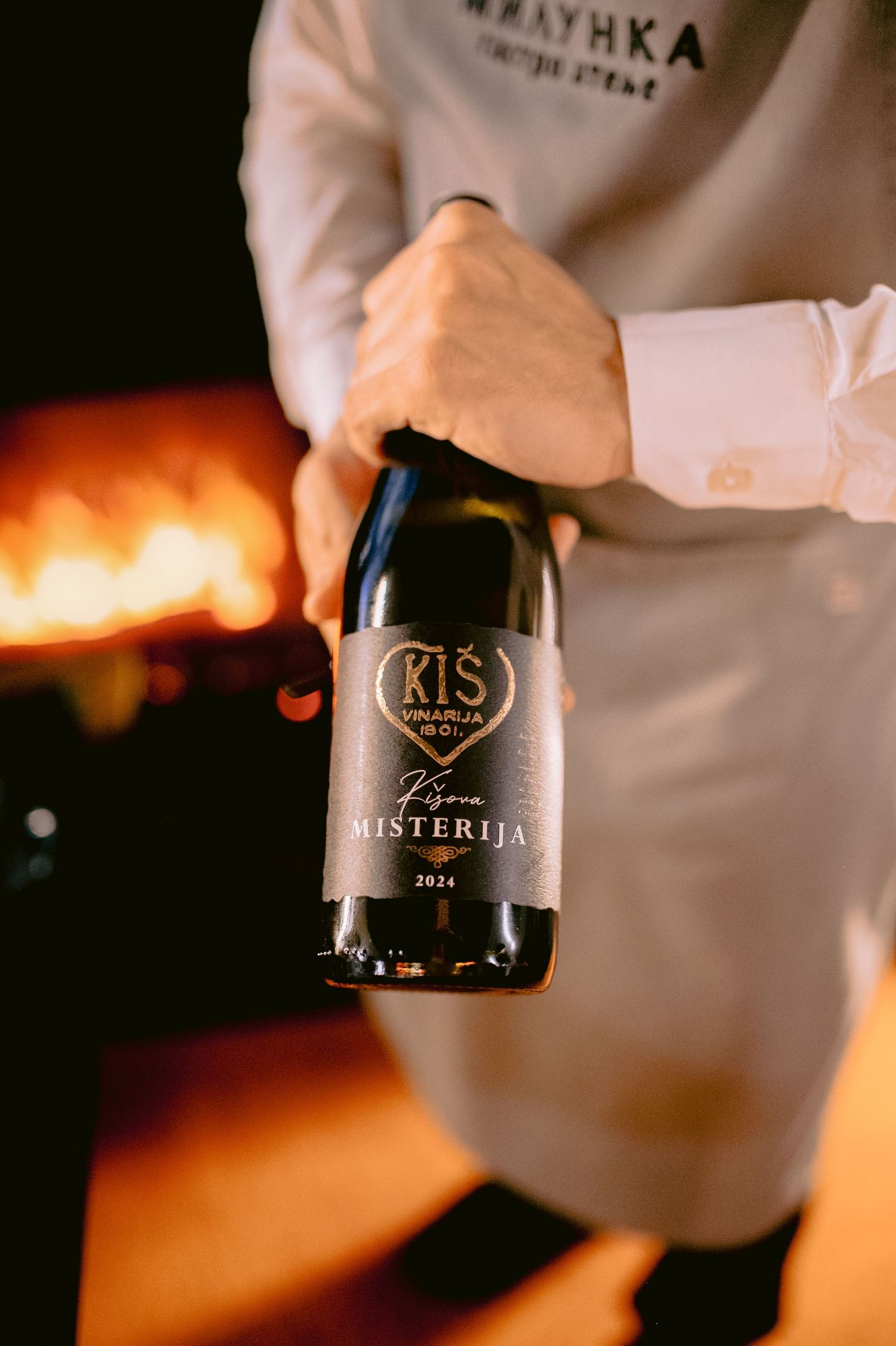 Wine bottles being showcased in a dimly lit setting with warm ambient lighting.