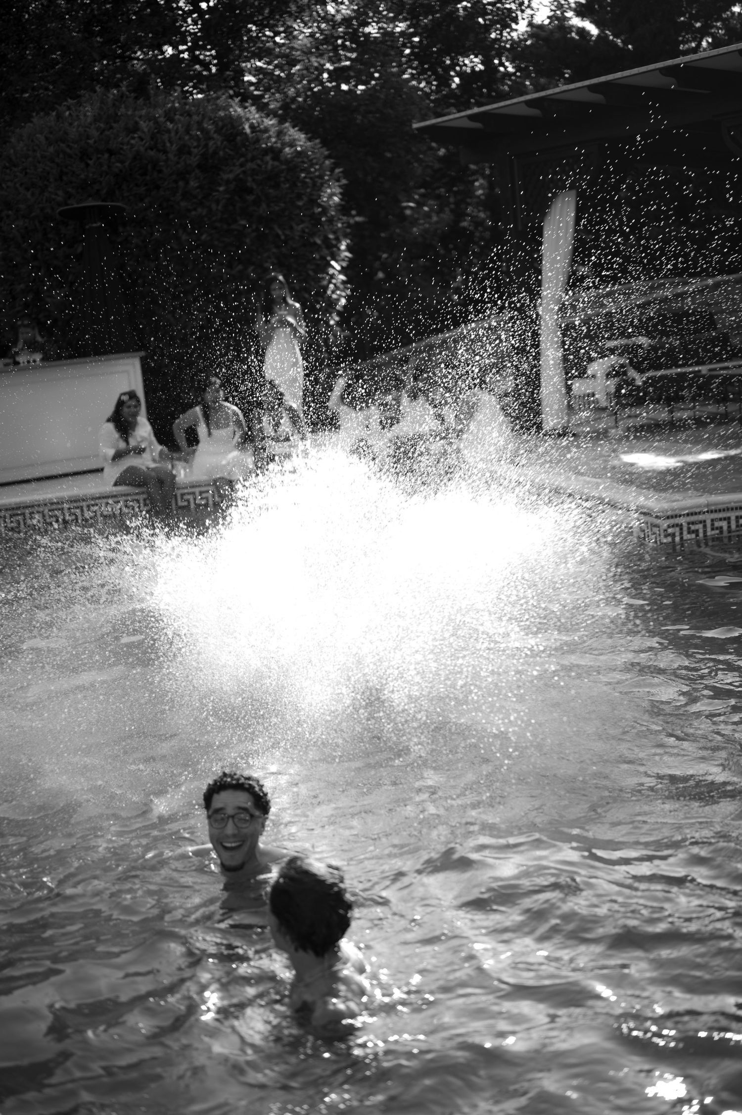 Crno-bijela fotografija gostiju koji prave prskanje u bazenu na pool party vjenčanju, Villa Slatina Banja Luka