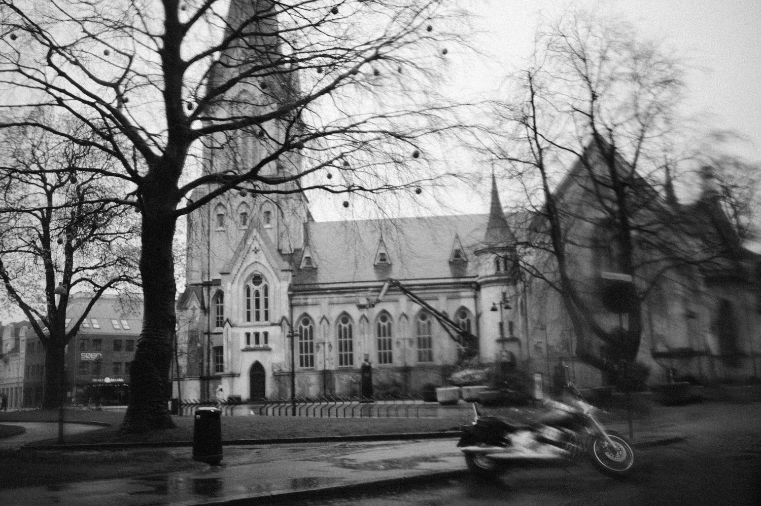 A black and white panoramic view of historic church buildings and bare trees in winter.