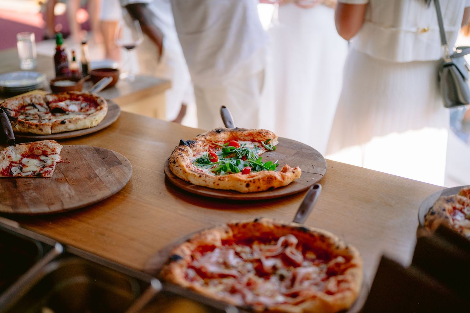 Svježe pečene napolitanske pizze sa bosiljkom na drvenim daskama, ketering na otvorenom u Villi Slatina Banja Luka