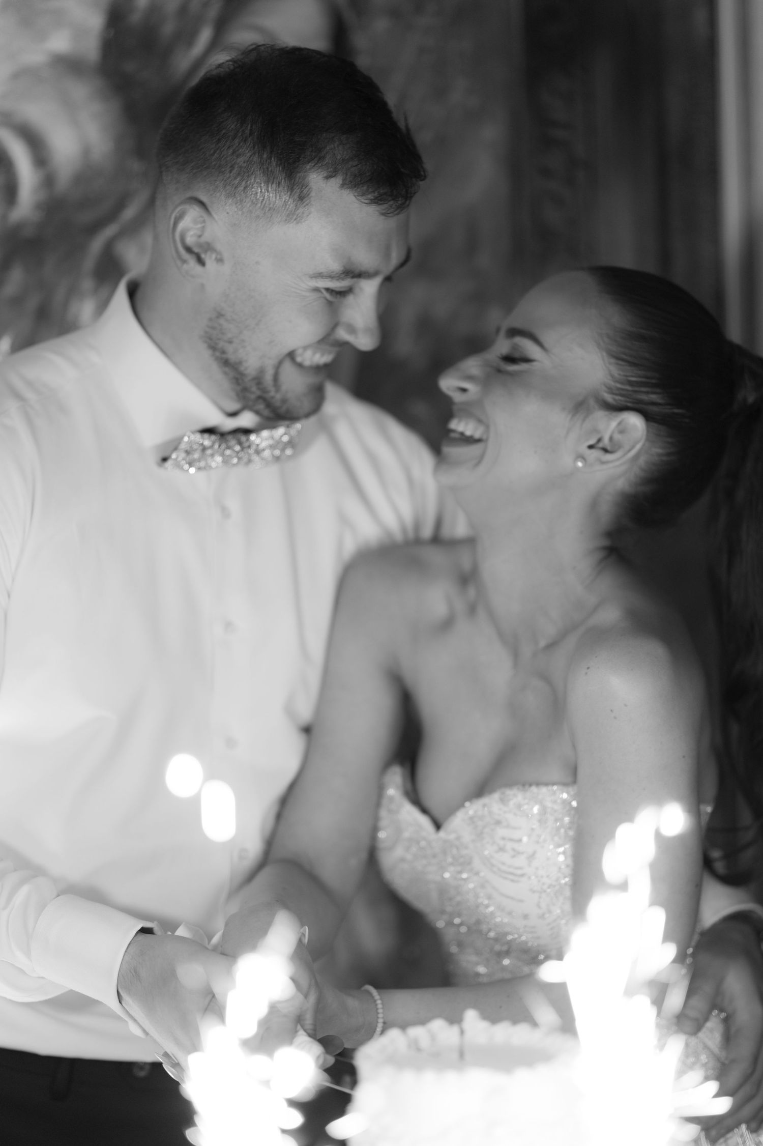 A romantic black and white photo sequence shows a couple sharing intimate moments near sparklers at their wedding reception.