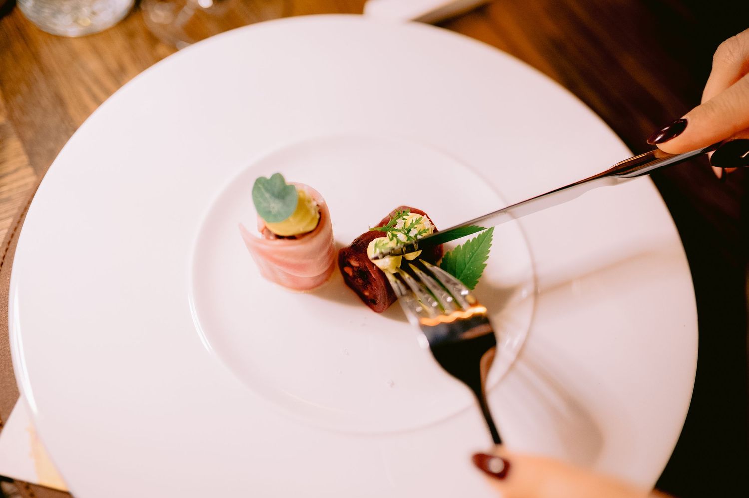Fine dining plates with delicate food presentation on white porcelain dishes.