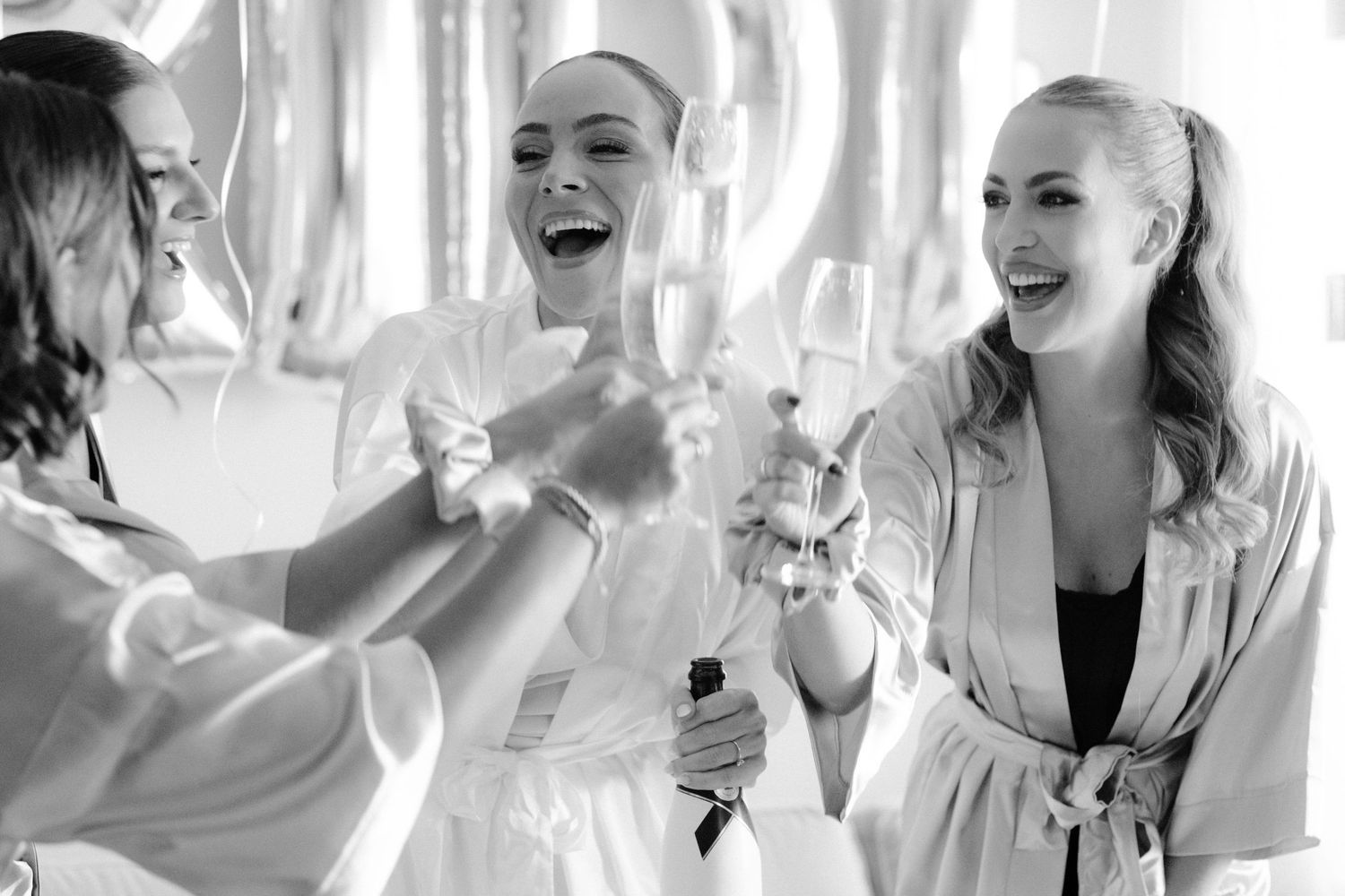A black and white collage of people laughing and smiling in candid moments.