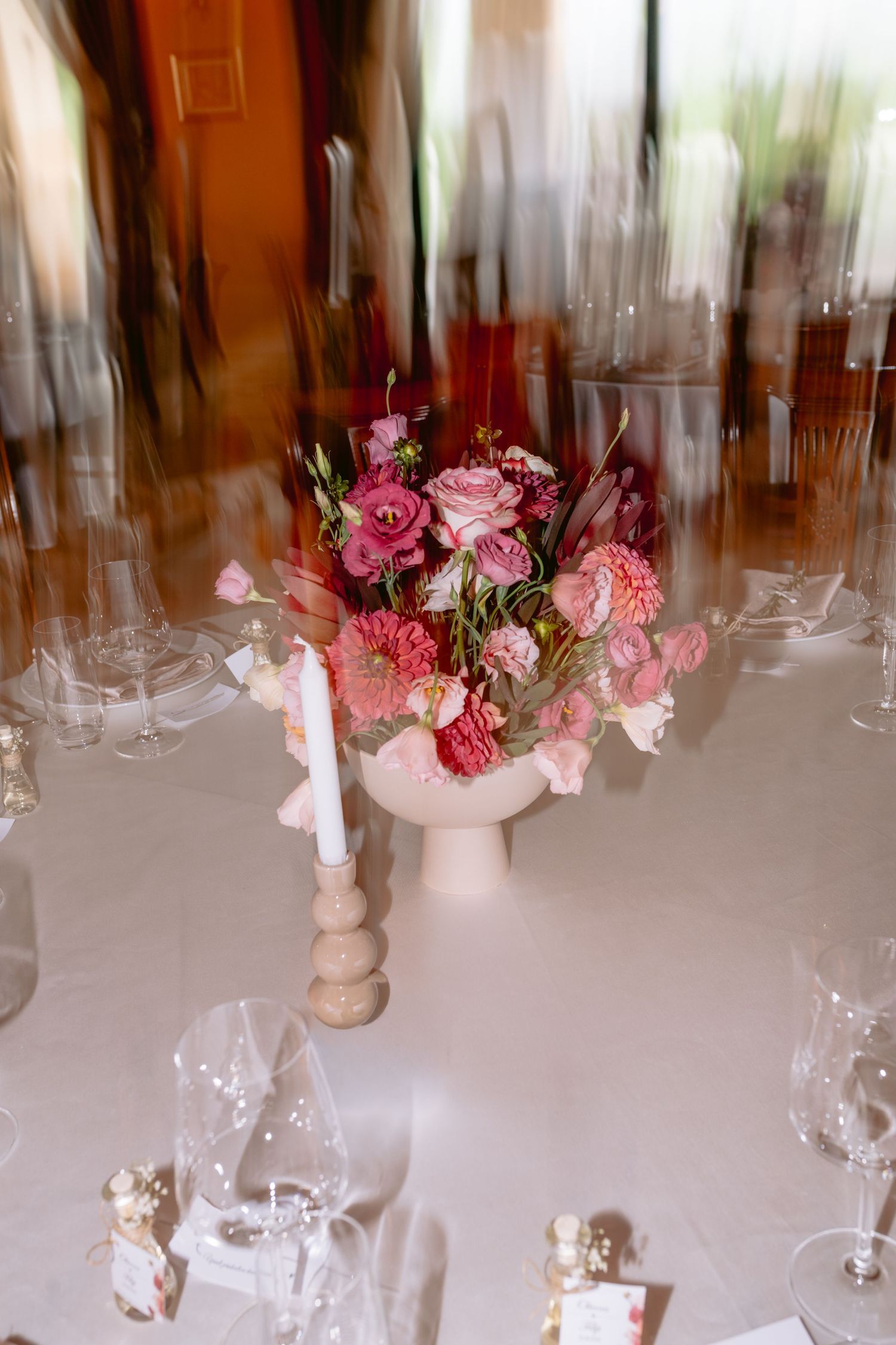 Elegant wedding table settings with pink floral centerpieces and crystal glassware.