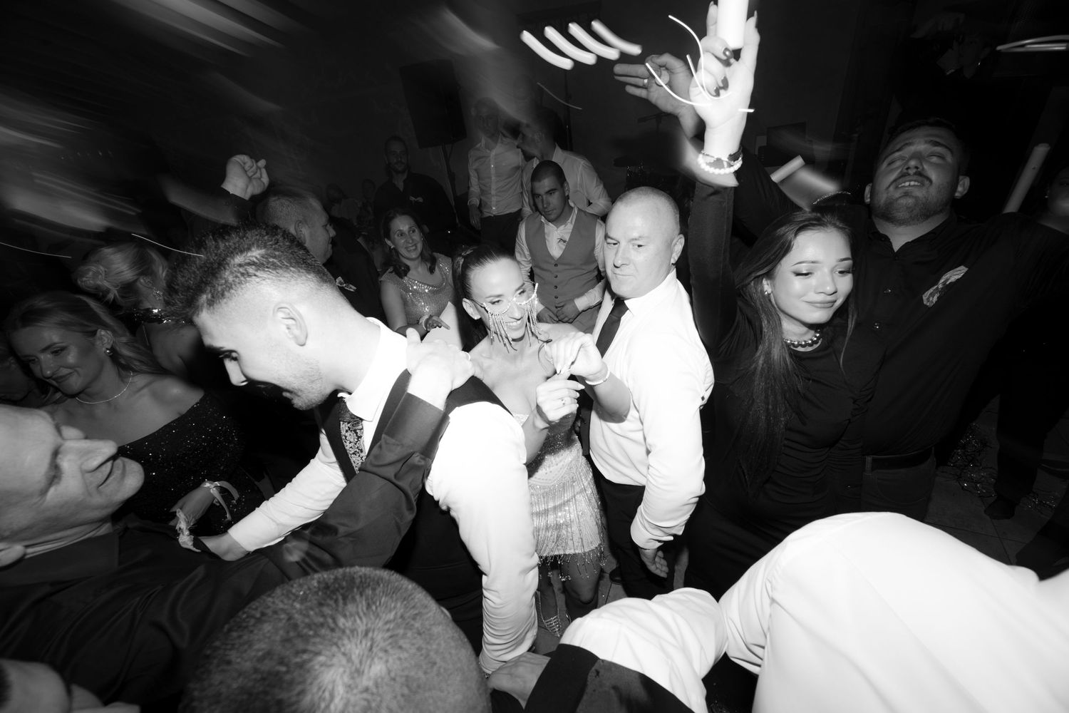 Black and white photo of a crowded dance floor with people dancing energetically at a nightclub or party.