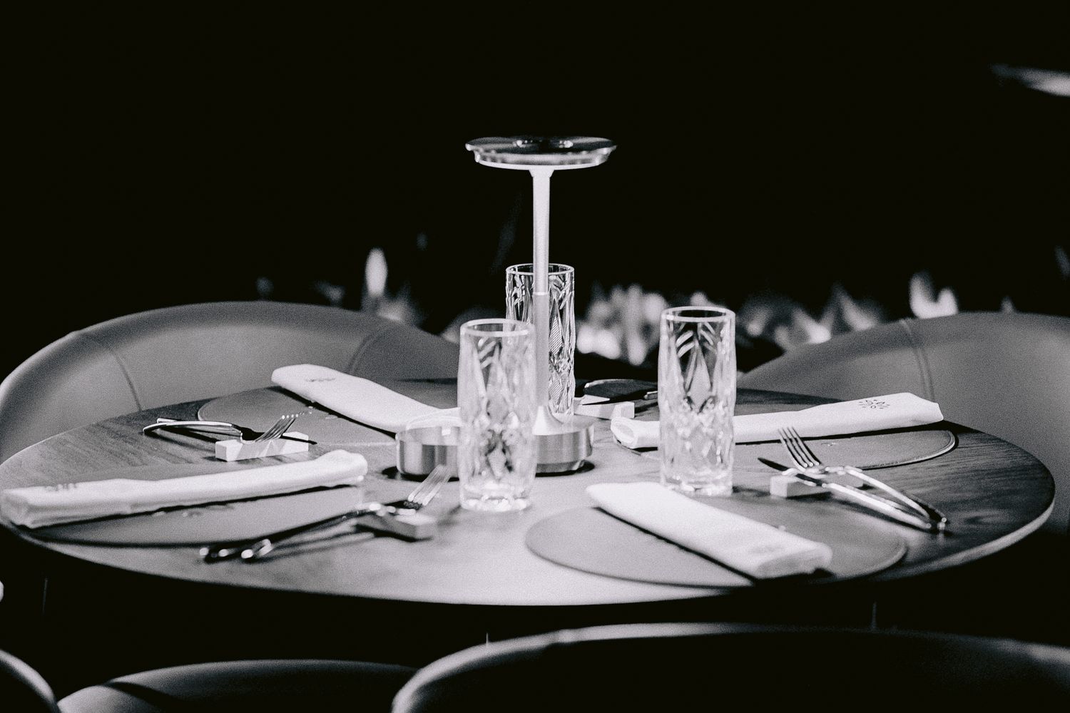 Minimalist table setting in black and white with elegant place settings and glassware.