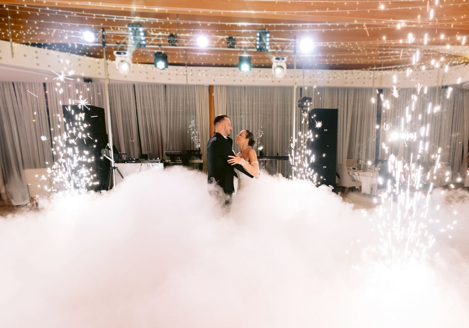 A sequence of sparkler fountains creating a dramatic light display at an indoor wedding reception.