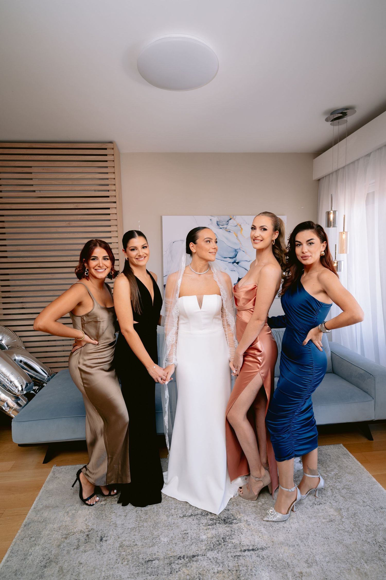 A group in formal attire poses together in a series of candid shots on a gray carpet in a bright room.