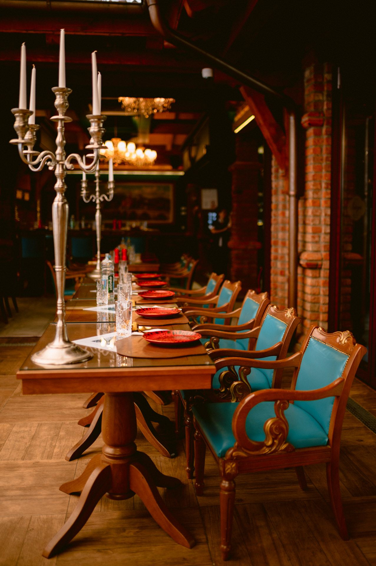 Elegant restaurant interior with turquoise chairs and candlelit tables.