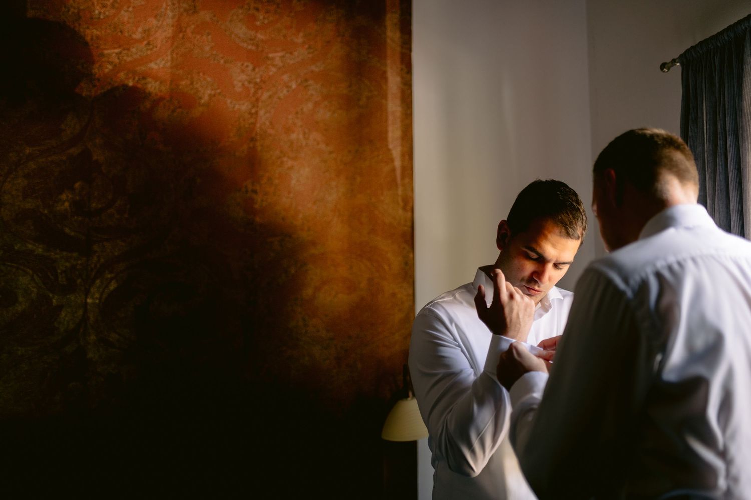 Emotional moment captured in warm lighting during wedding preparations.