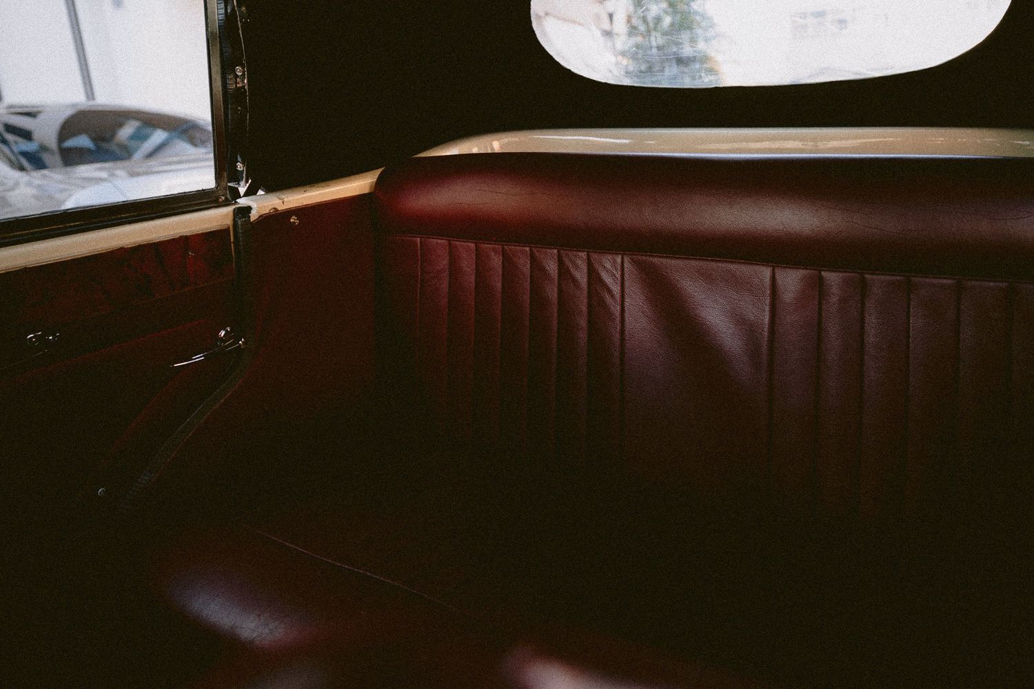 Dark leather interior of a classic vintage car with elegant upholstery.