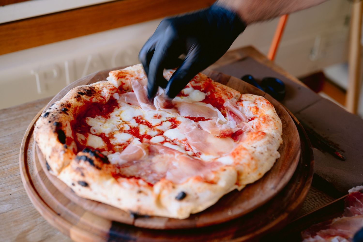 Kuhar priprema i siječe svježu napolitansku pizzu na drvenoj daski, Villa Slatina Banja Luka