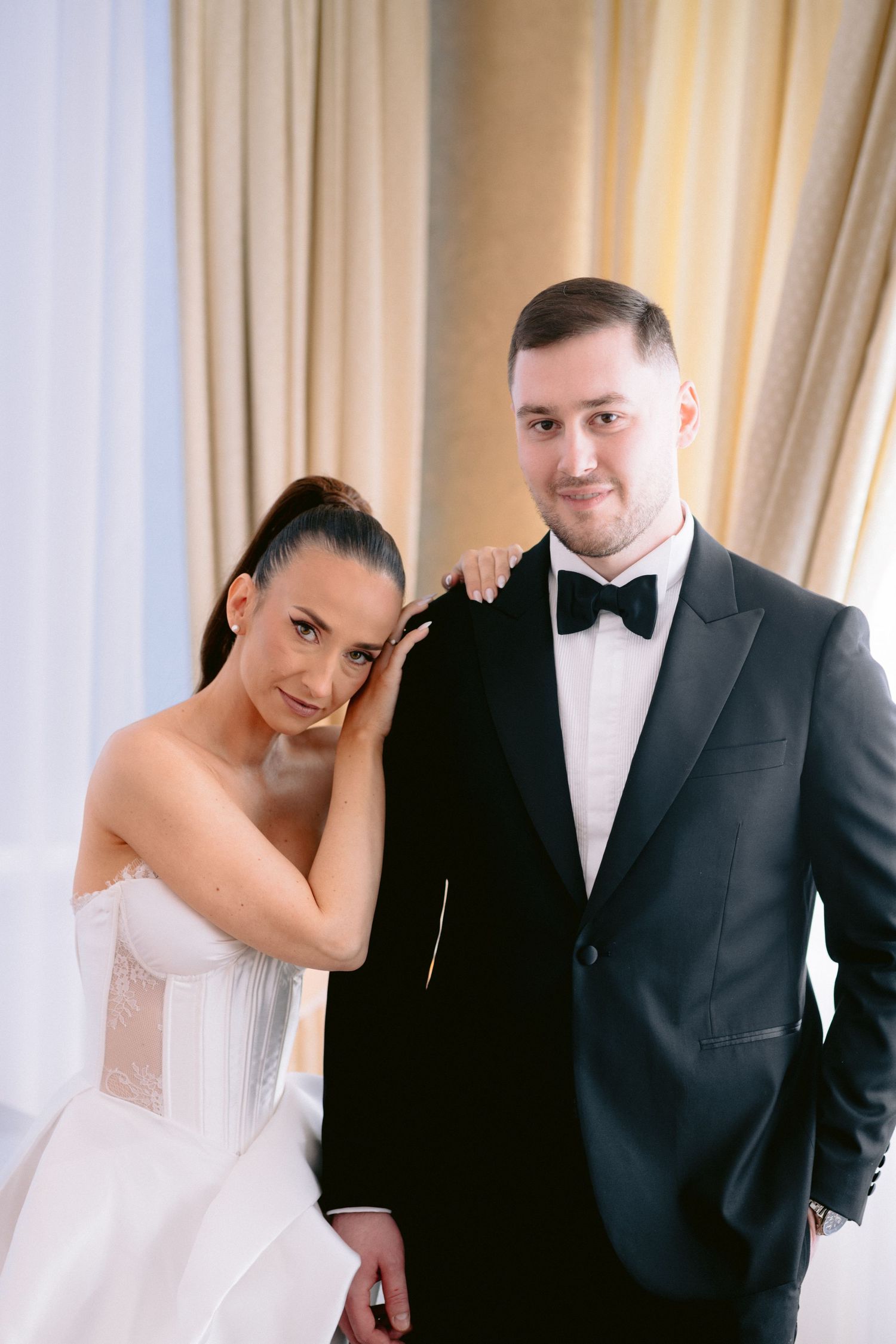 A bride and groom share playful candid moments in a series of three wedding photos against white curtains.