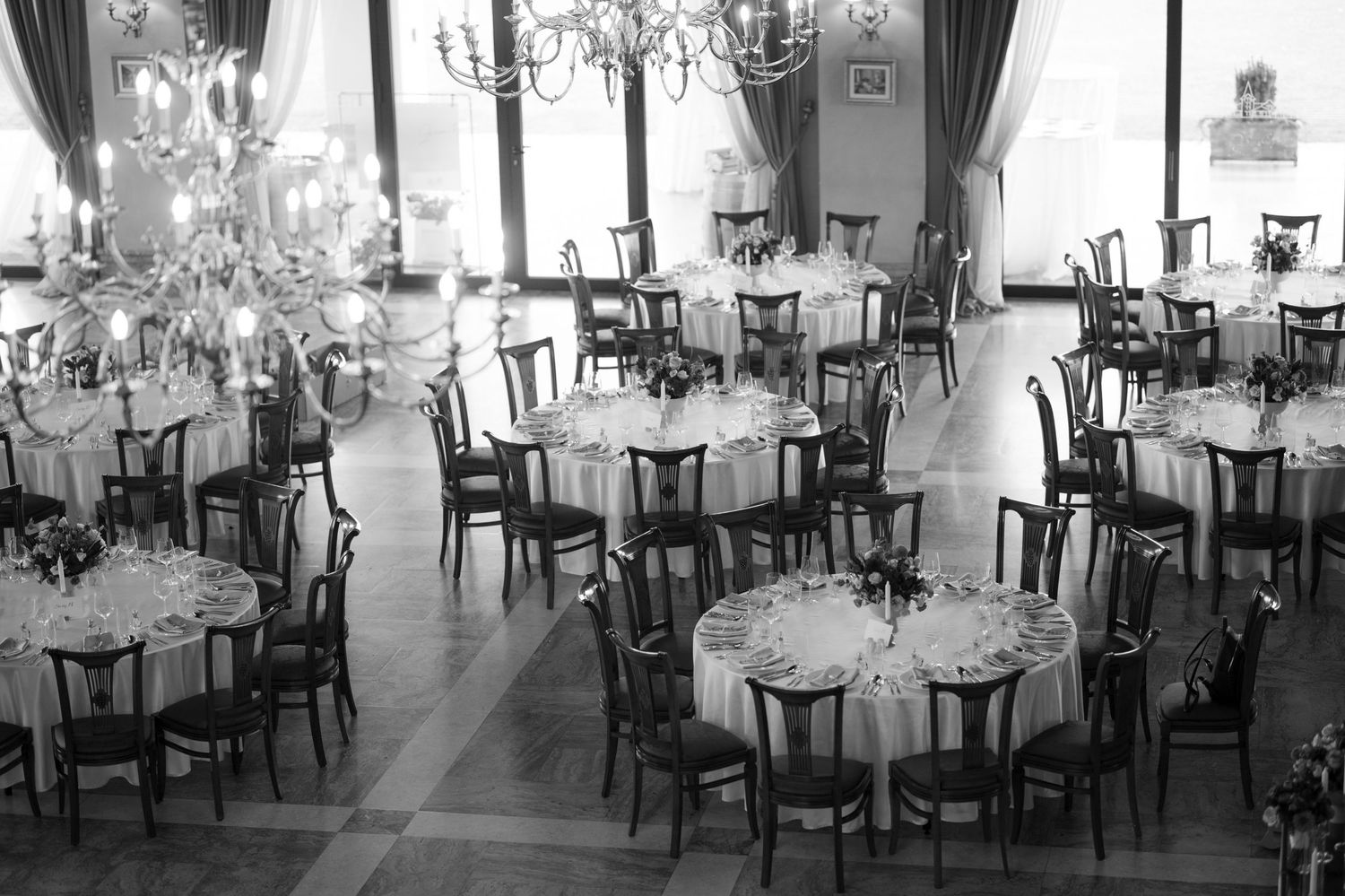 Spacious wedding reception venue with rows of tables and dramatic lighting.