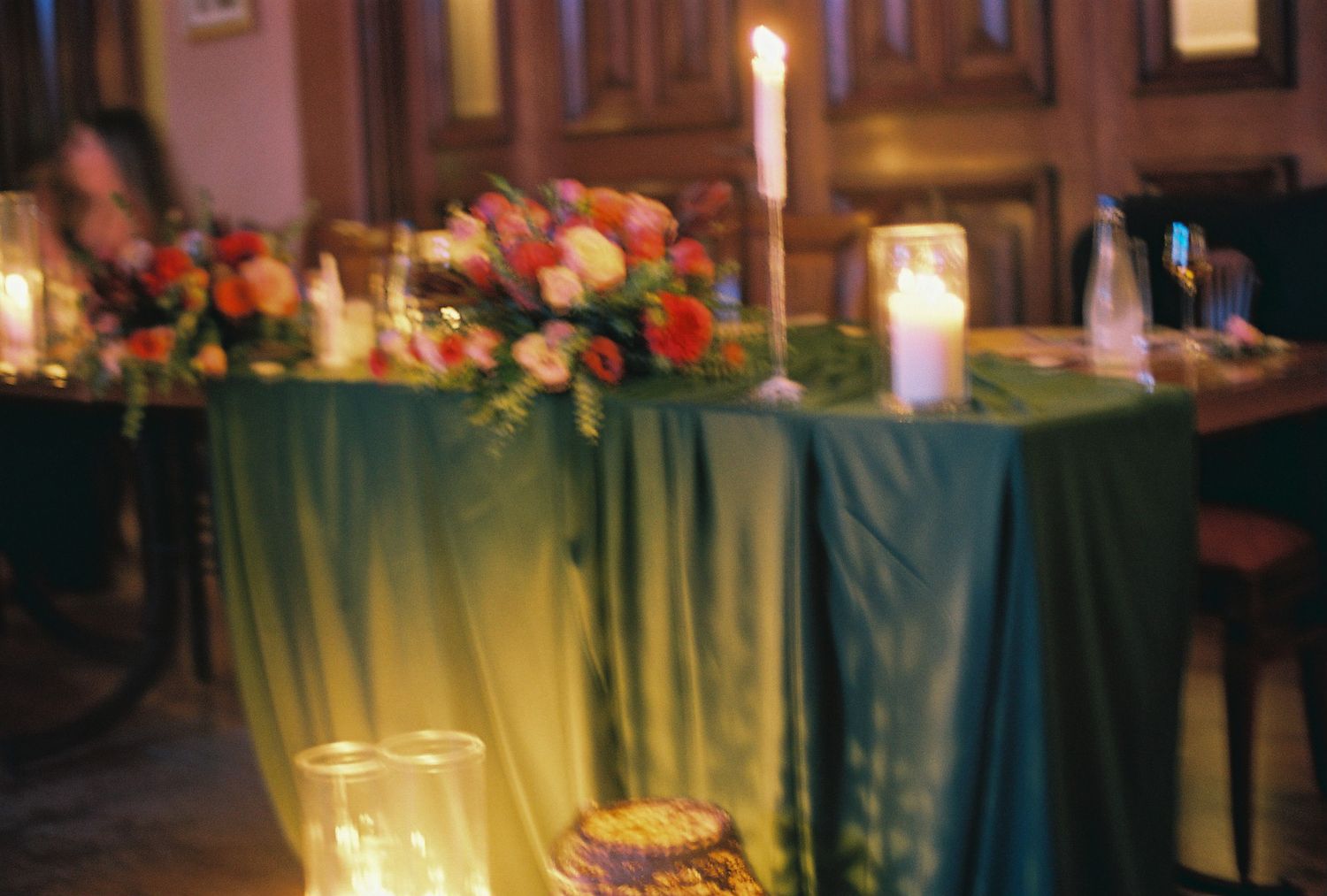 A romantic candlelit dinner reception table decorated with floral centerpieces and elegant place settings.