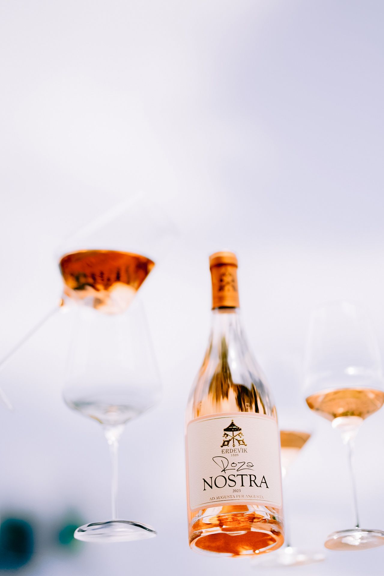 Nostra wine bottle and glassware photographed with soft lighting and minimal composition.