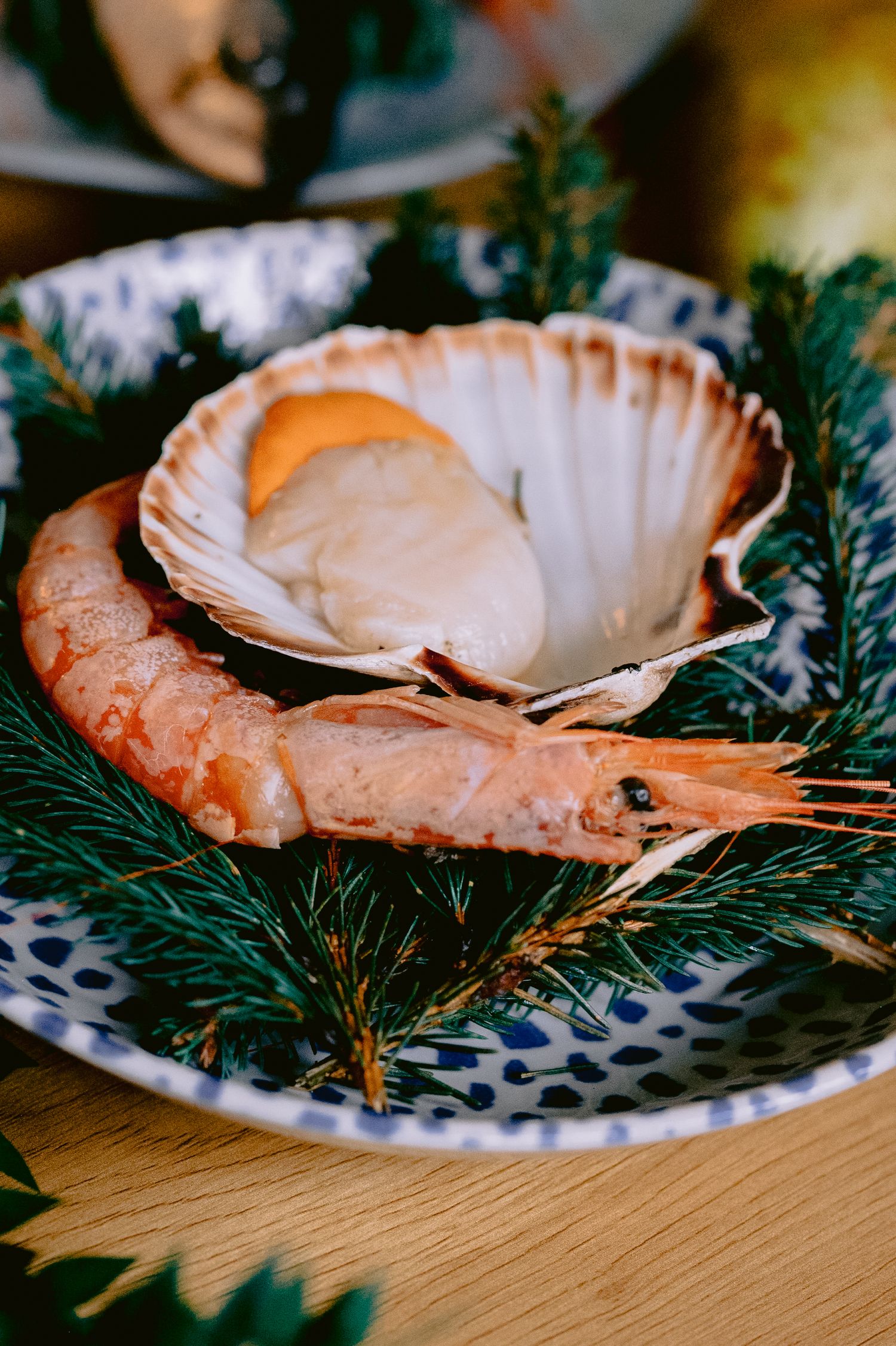 Fresh prawns arranged on a decorative blue and white plate garnished with fresh dill.
