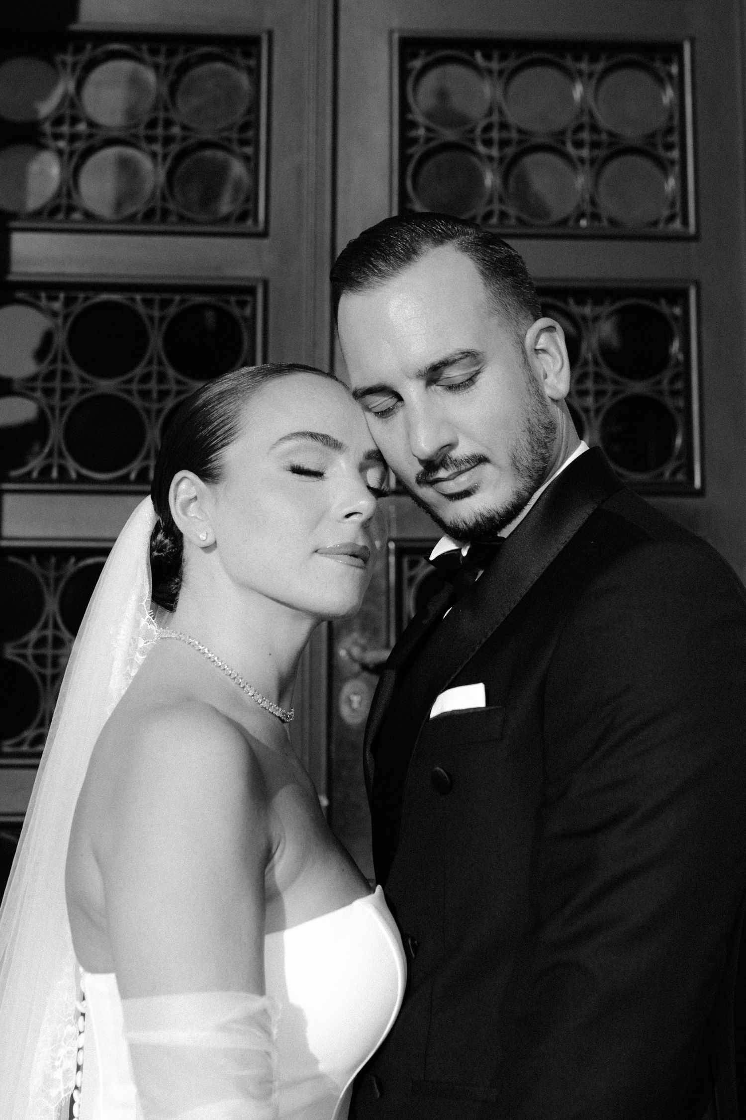 A black and white wedding photo series showing tender romantic moments between a bride and groom.