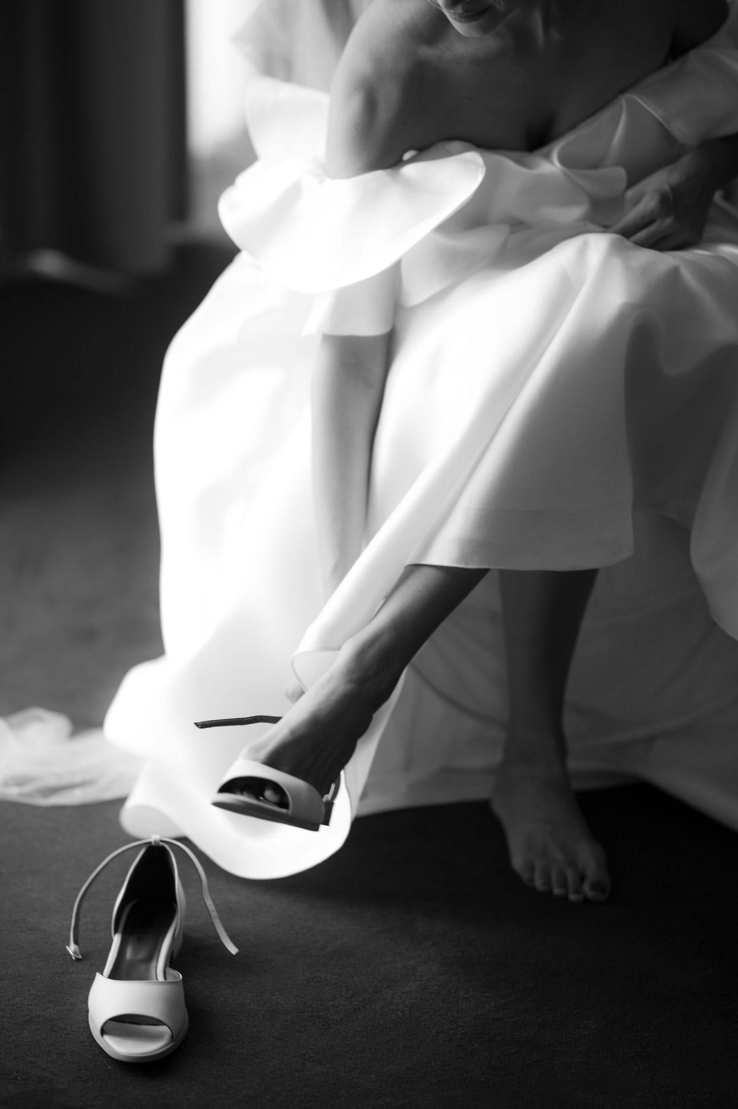 Close-up shots of white wedding shoes and dress details against a dark background.