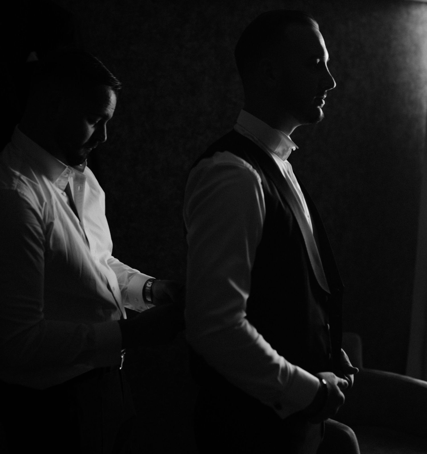 A dark and moody black and white photo series showing two people interacting in dramatic lighting.