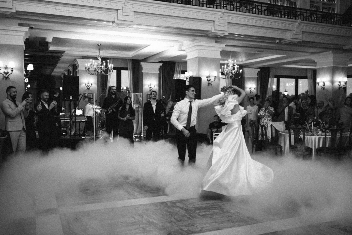 A sequence of black and white photos showing couples dancing in a ballroom filled with atmospheric fog effects.