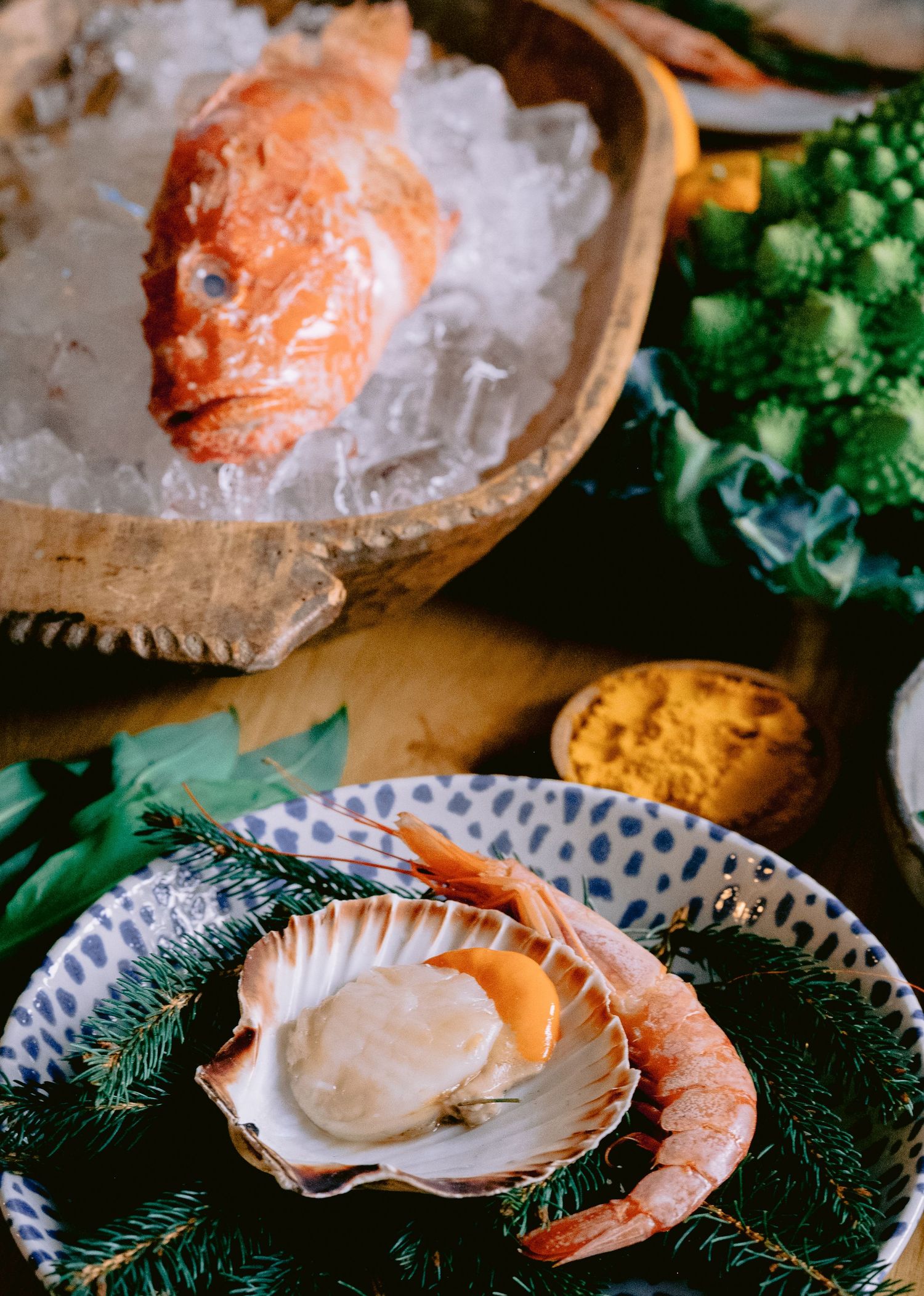 Fresh seafood display featuring oysters and shrimp on ice with citrus garnishes.