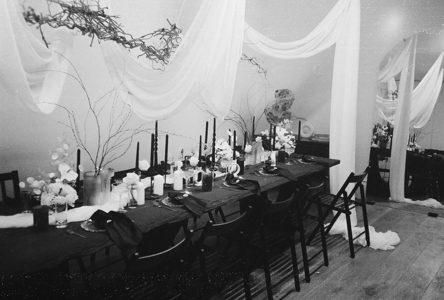 Multiple computer workstations arranged in a line with dark chairs visible in a monochrome institutional setting.