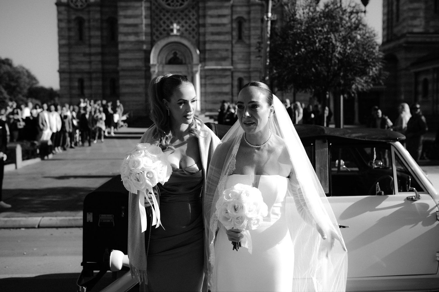 A black and white wedding photo collage showing romantic moments between newlyweds outdoors near a brick building.