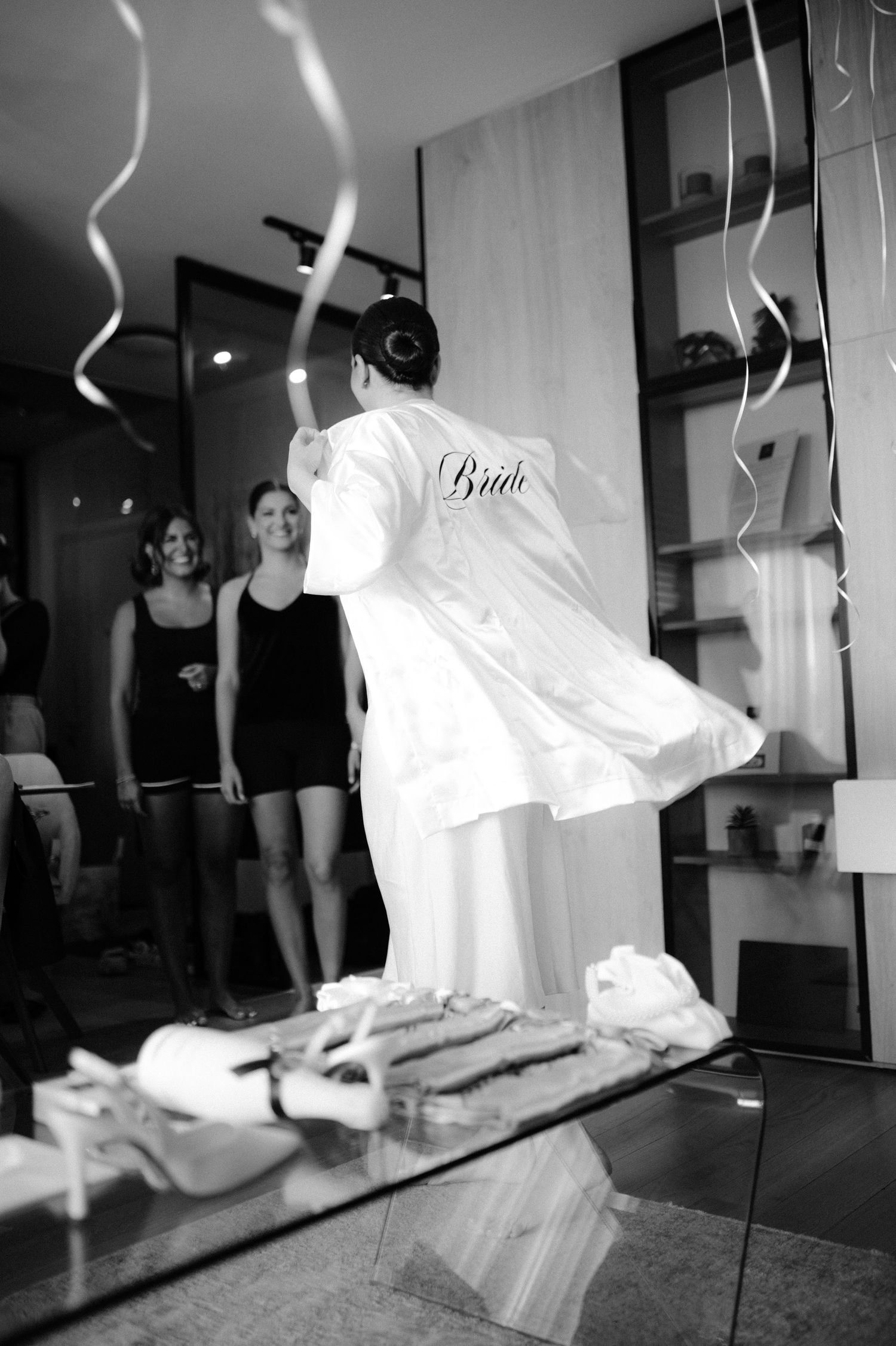 A series of black and white photographs showing wedding dress preparations with hanging gowns and reflections in mirrors.