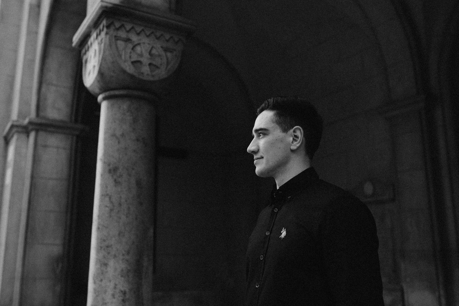 Dramatic wedding portraits captured under stone archways with natural lighting.