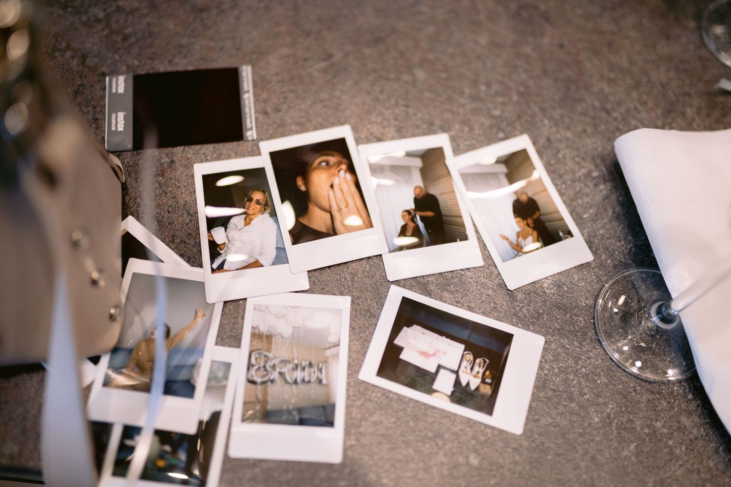Vintage Polaroid instant photographs scattered on a textured concrete or stone surface.
