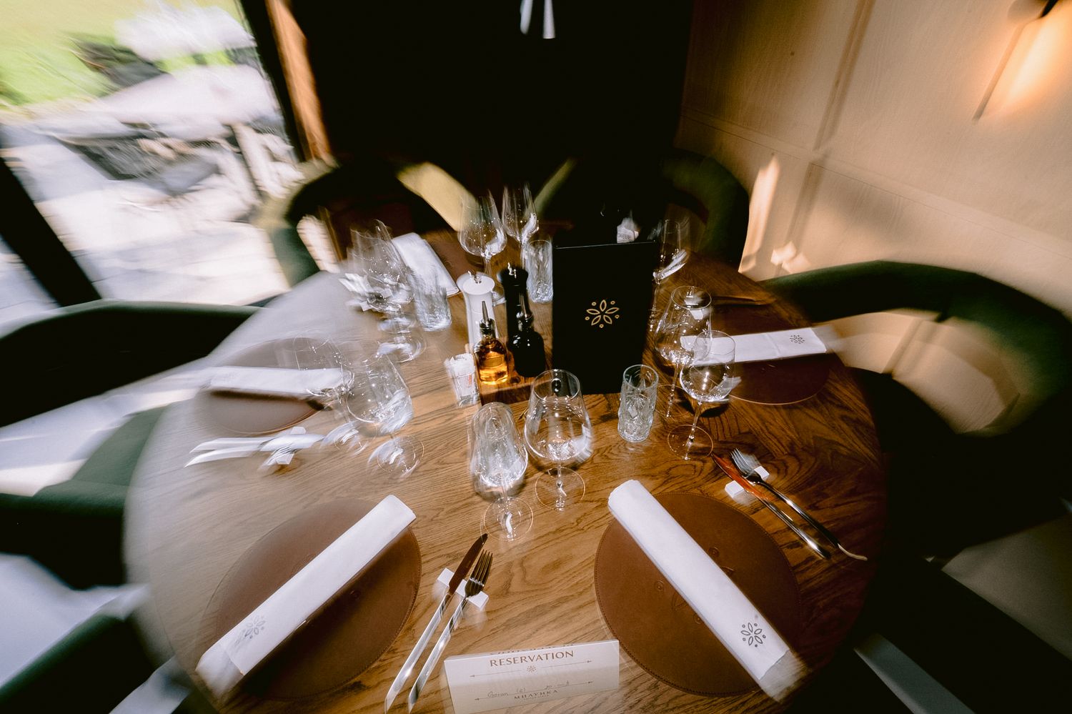 Fine dining place settings with white linens and crystal stemware.
