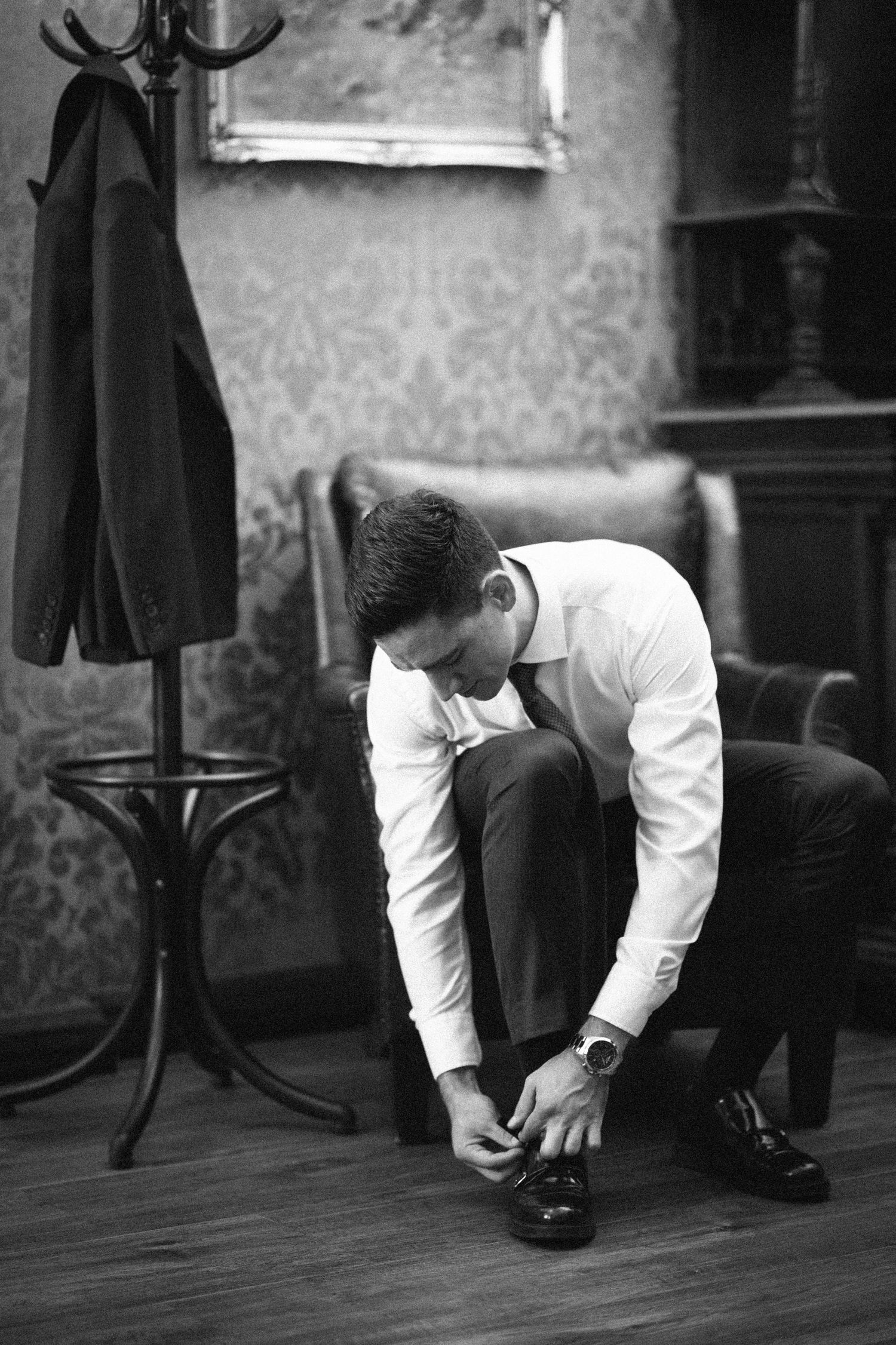 A sequence of black and white photos showing someone in a white shirt bending down to search the floor.