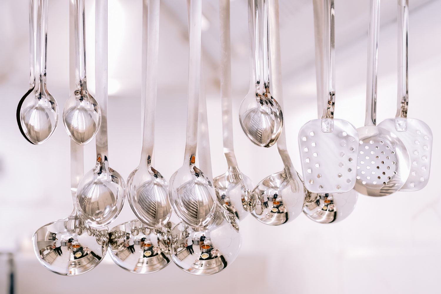 Crystal wine glasses hanging in rows from a ceiling display.