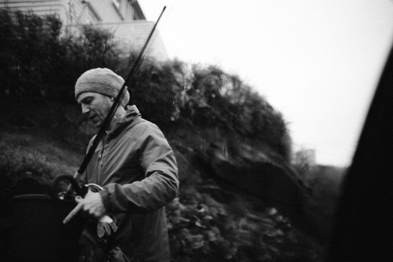 A series of black and white photographs showing someone in winter clothing walking through a snowy landscape.