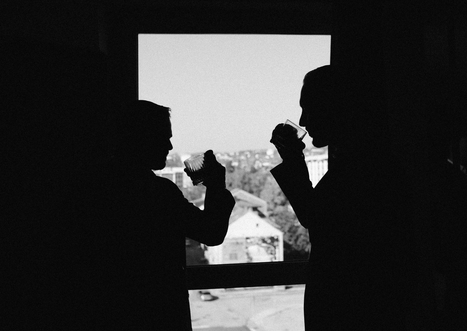 A series of black and white silhouettes showing a person reading documents in a dark setting.