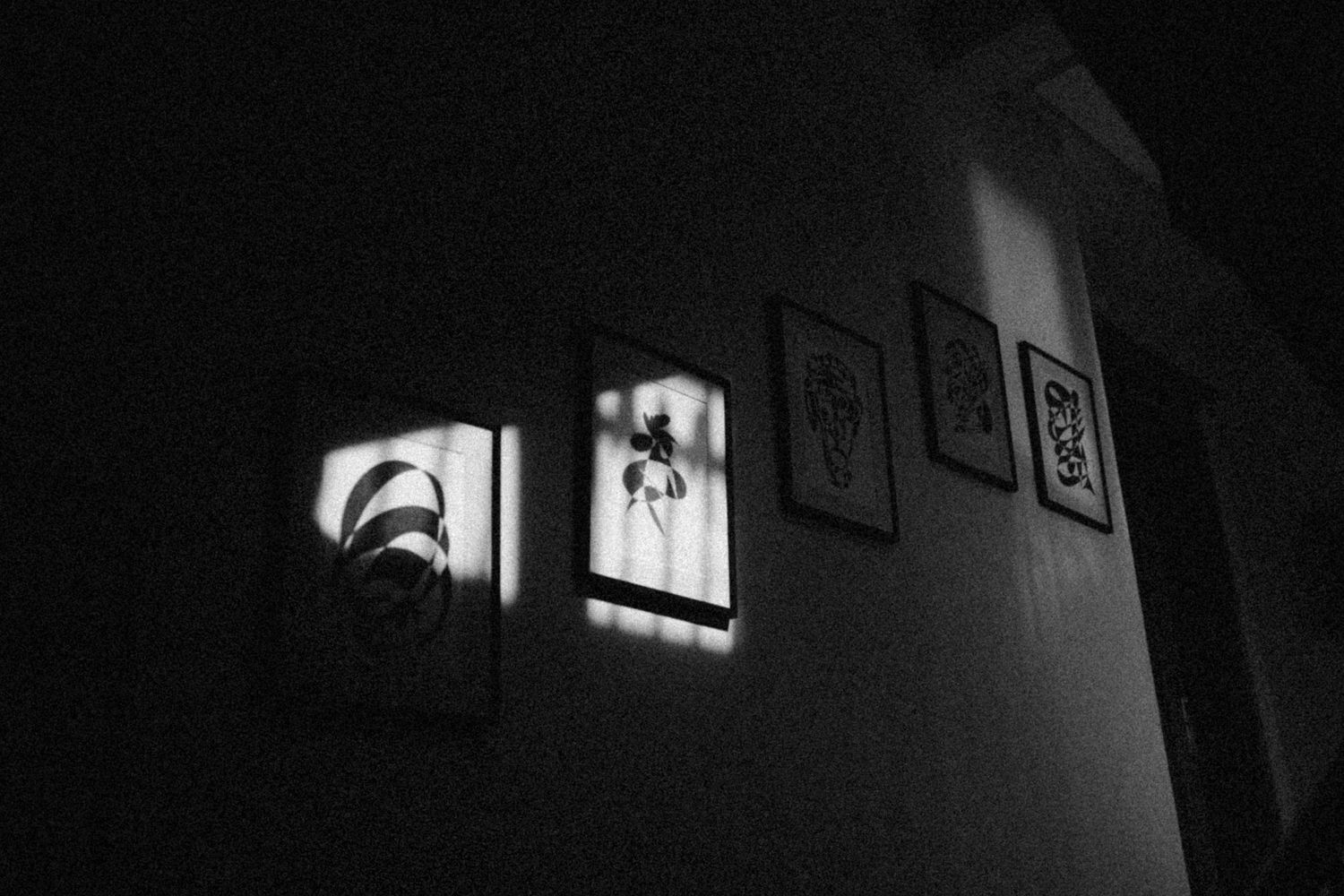 Black and white film strip showing dark silhouettes against a bright window in a dramatic noir style composition.