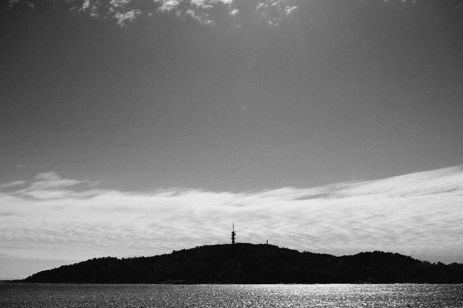 A dramatic black and white landscape series showing mountains, fields and silhouettes against moody skies.