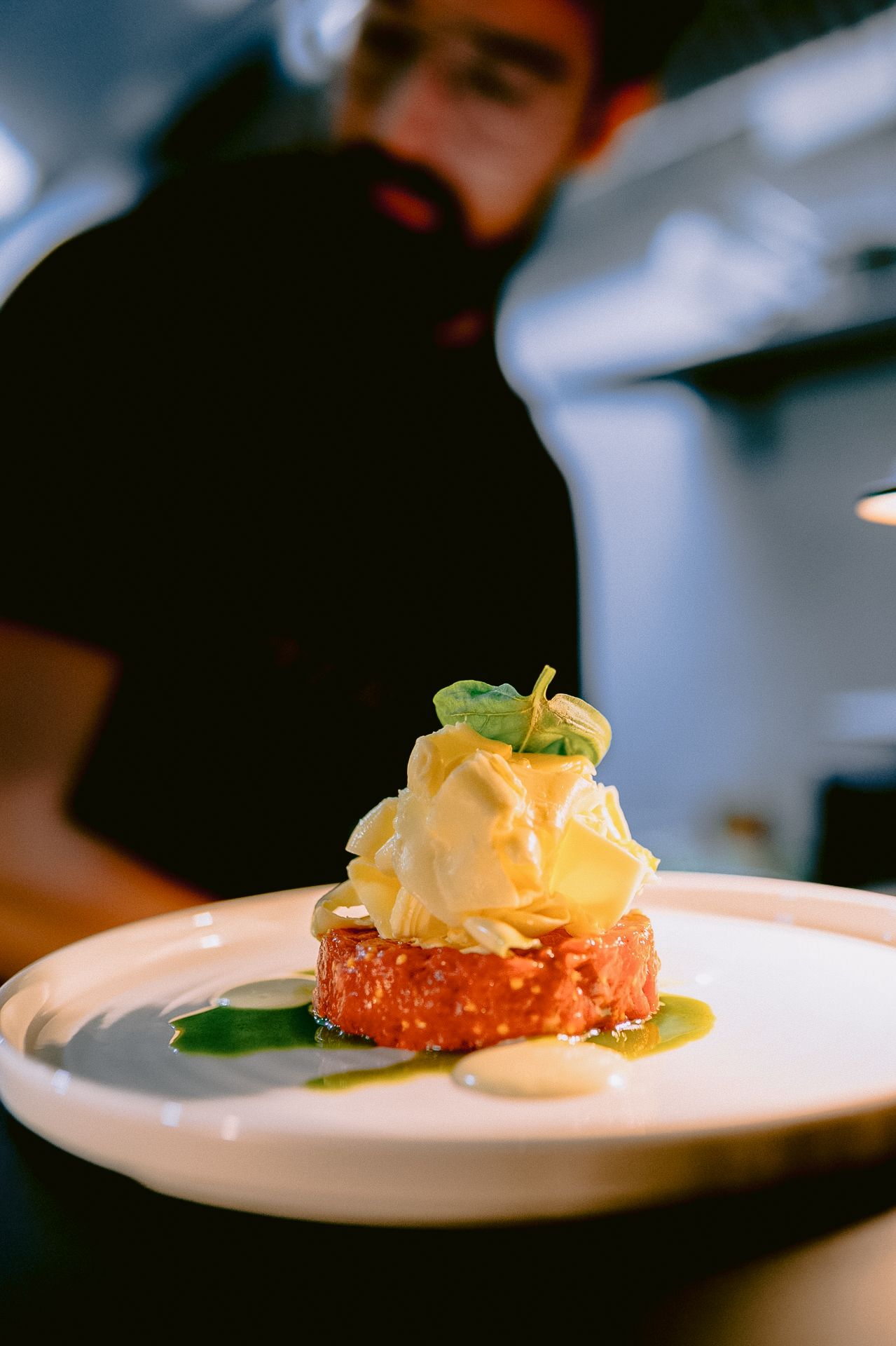 Beautifully plated dish with garnish and sauce on white plate.