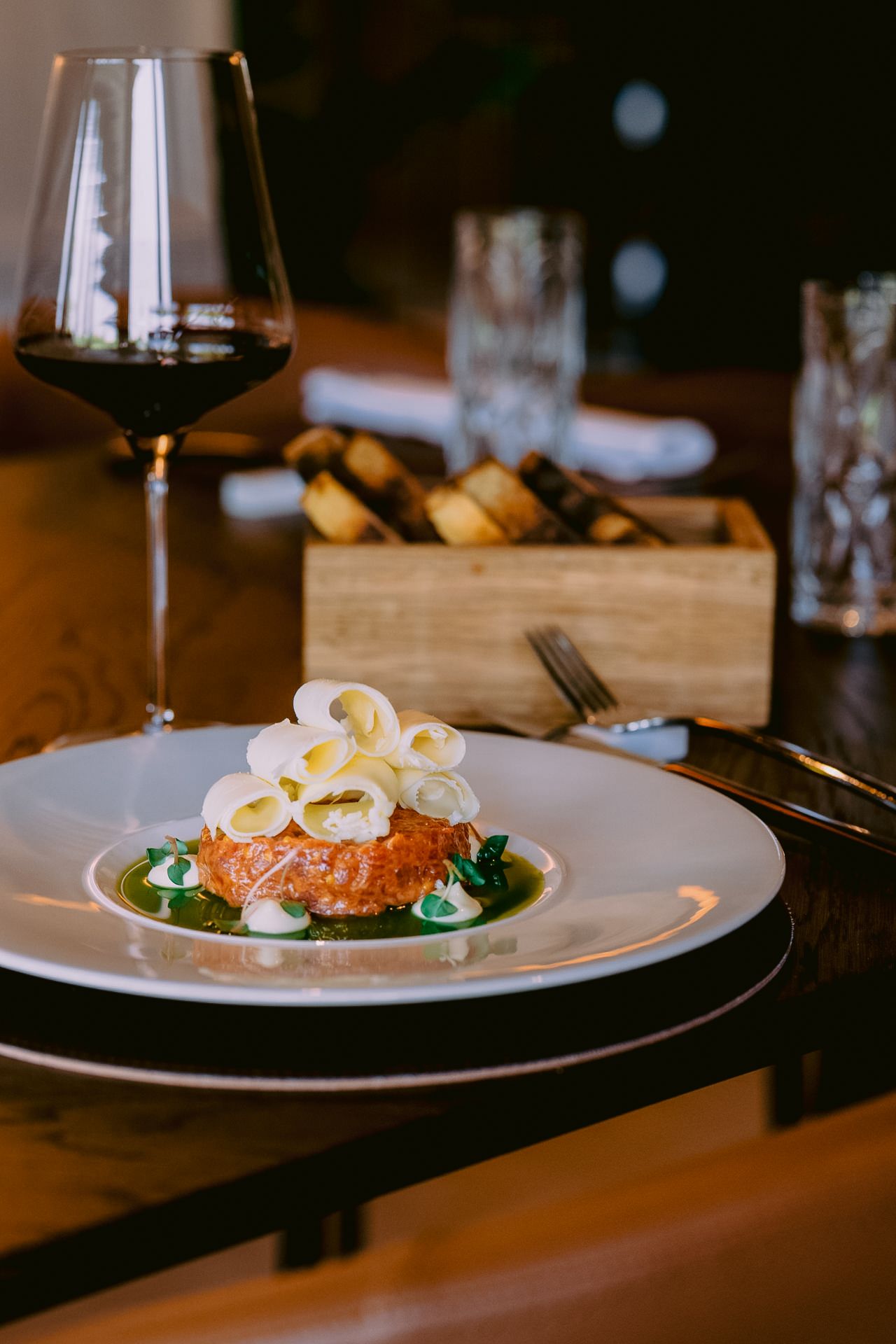 Elegant plated dish featuring salmon with white garnishes on dark plates.