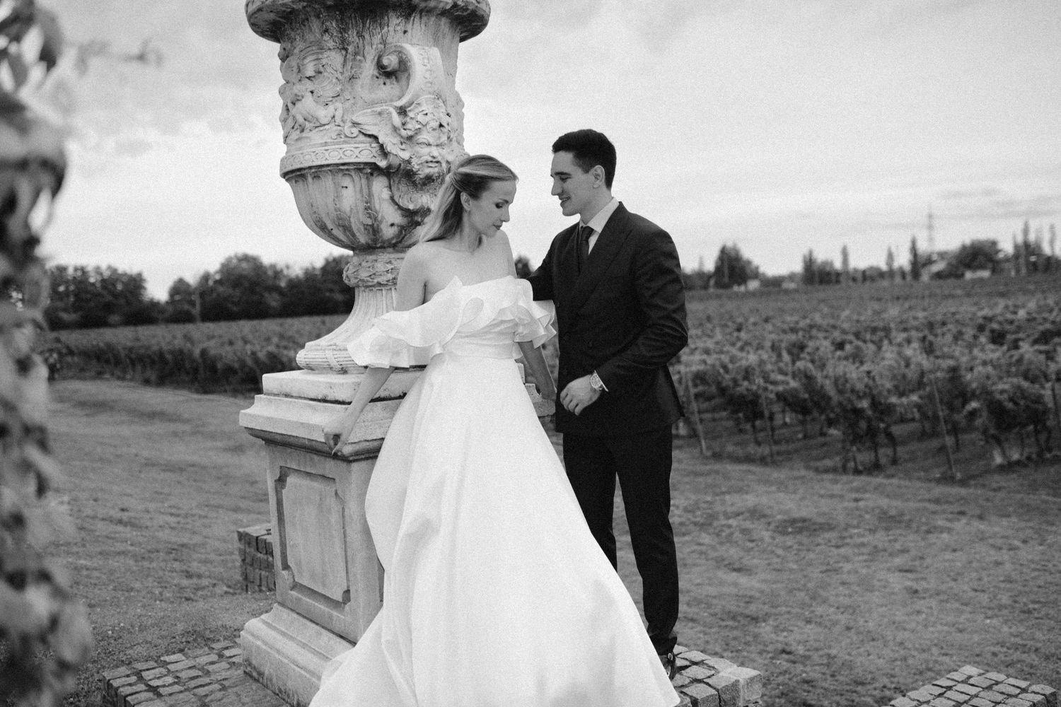 A romantic wedding couple shares intimate moments in front of a European-style building with ornate architecture.