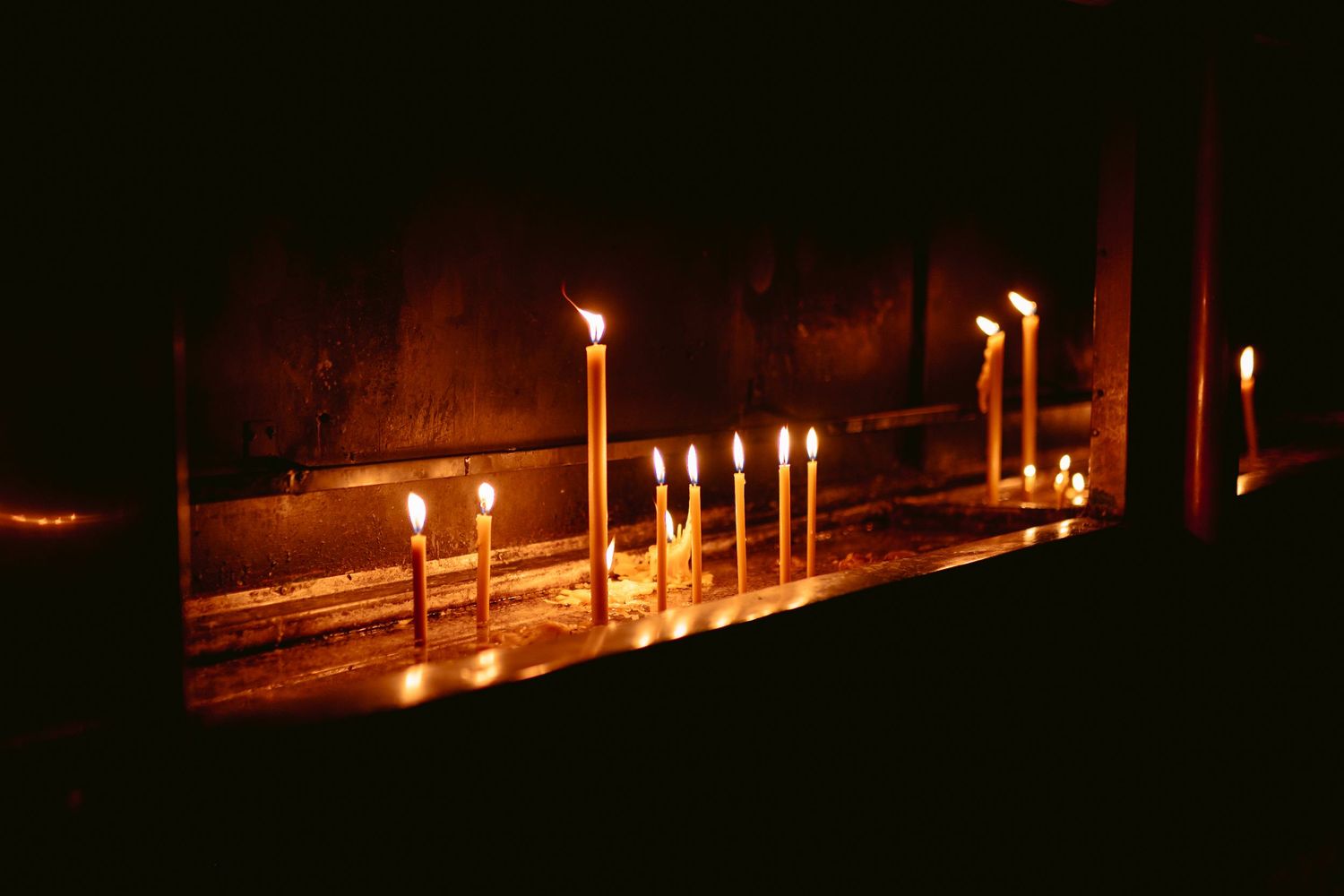 Glowing candles illuminate a dark path at night creating a peaceful and mystical atmosphere.