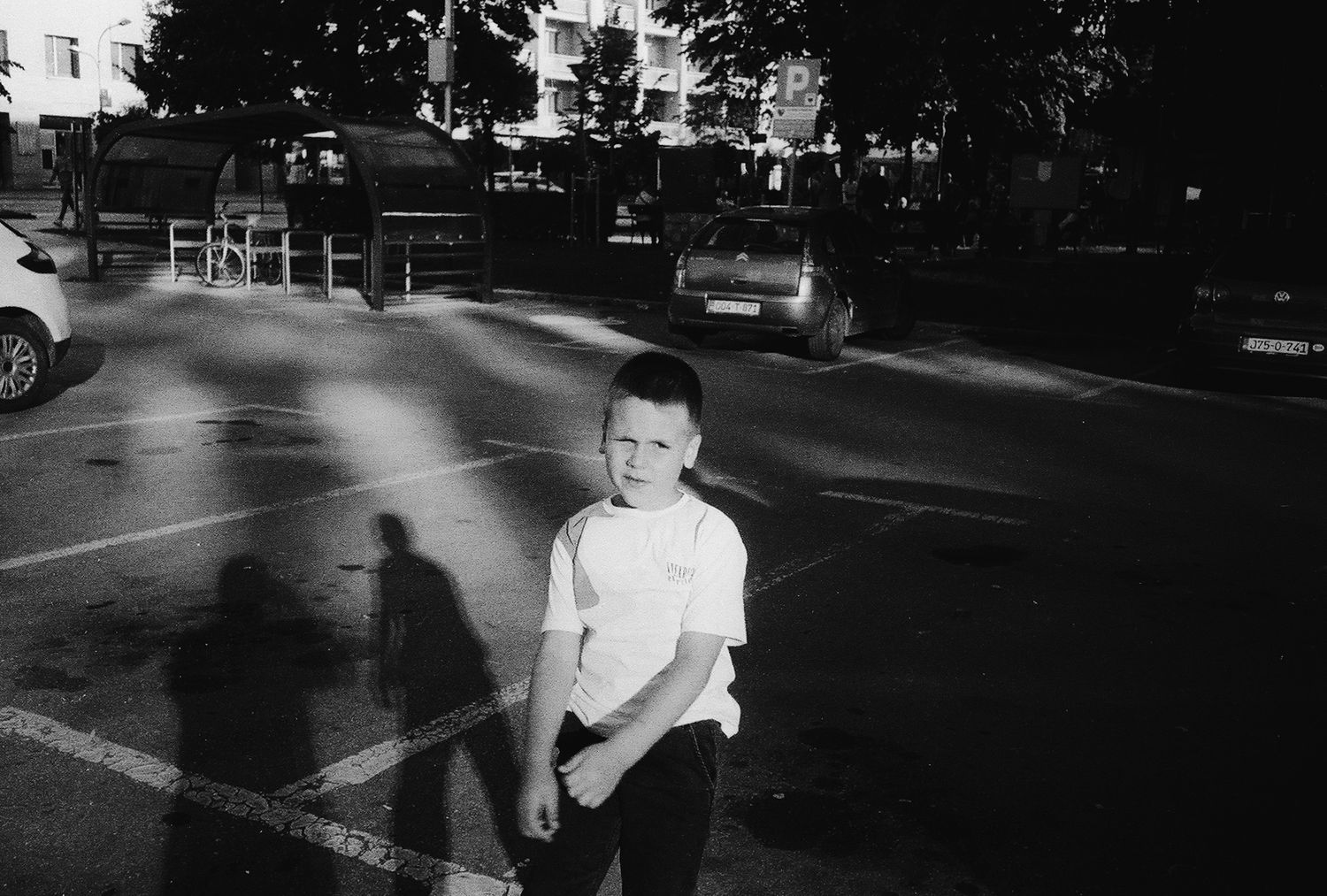 A black and white street photograph showing blurred motion and movement in an urban setting.