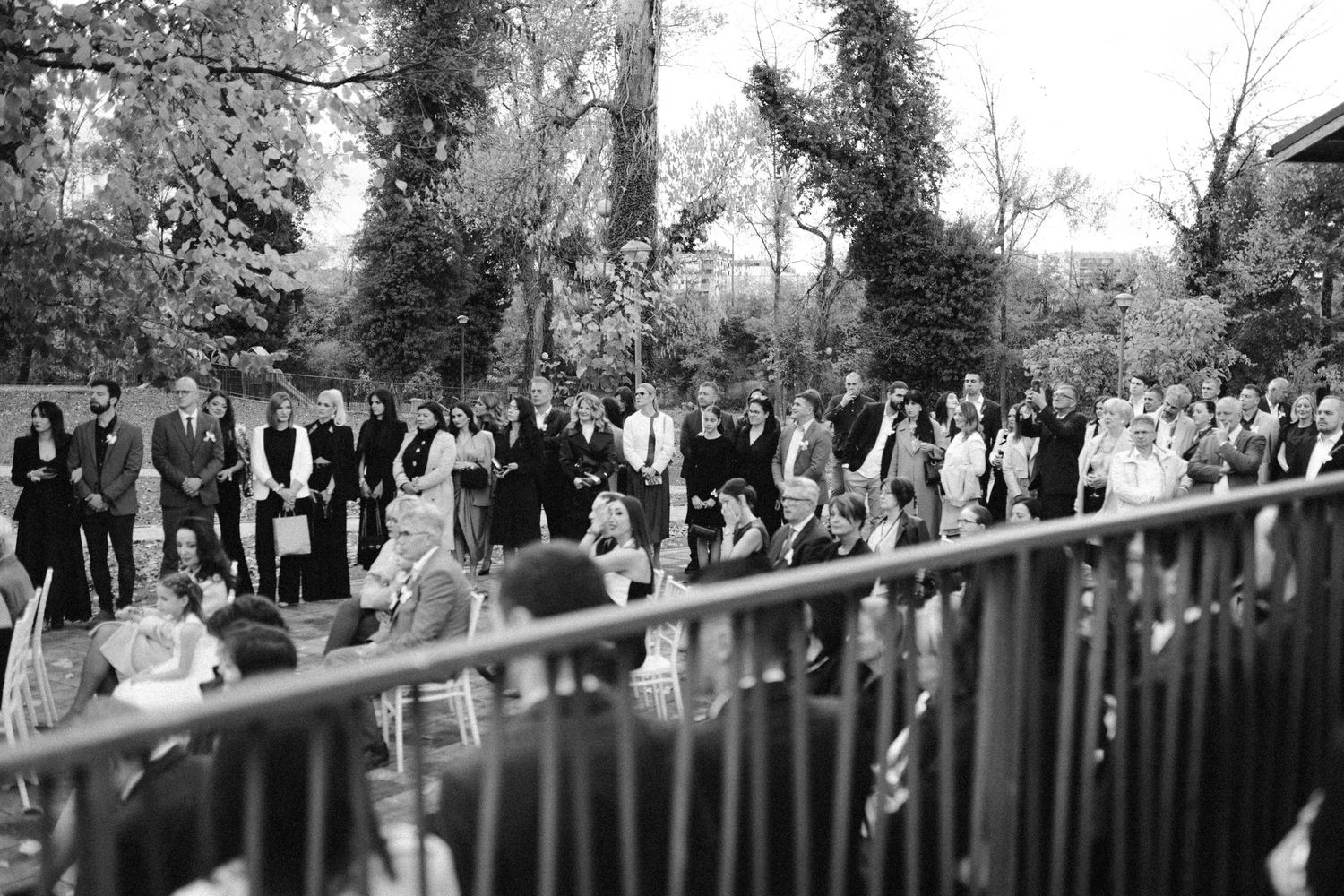 Wedding guests seated in rows at an outdoor ceremony venue.