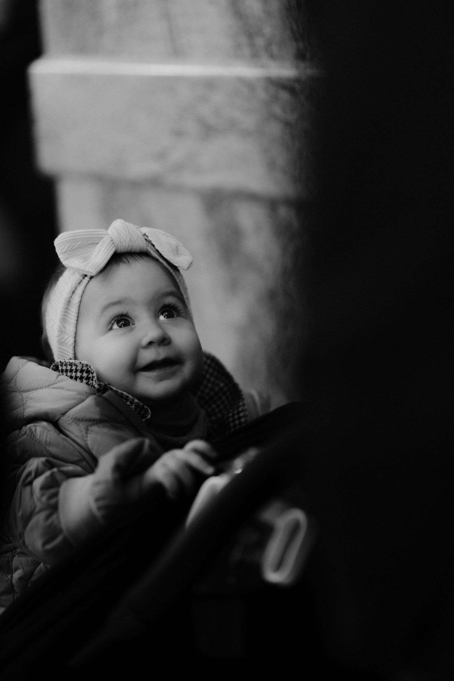 Black and white artistic photo series showing a baby looking up with curiosity in different poses and angles.