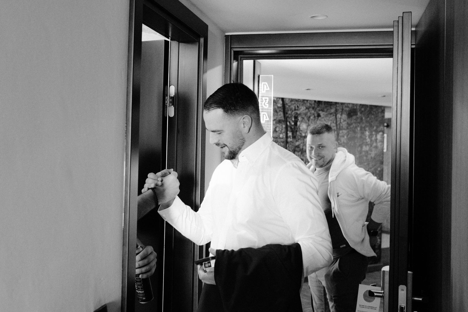 A sequence of four black and white photos showing a person opening a door and entering a room.