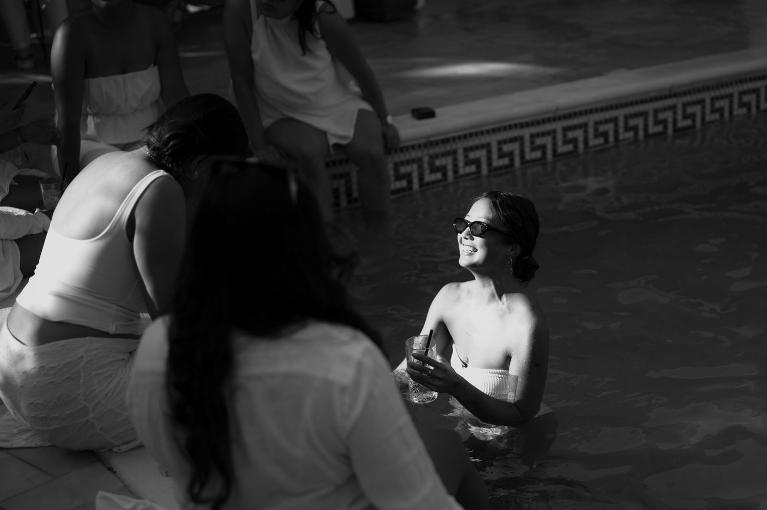 Crno-bijela fotografija gošći kako se opuštaju u bazenu na pool party vjenčanju, Villa Slatina Banja Luka