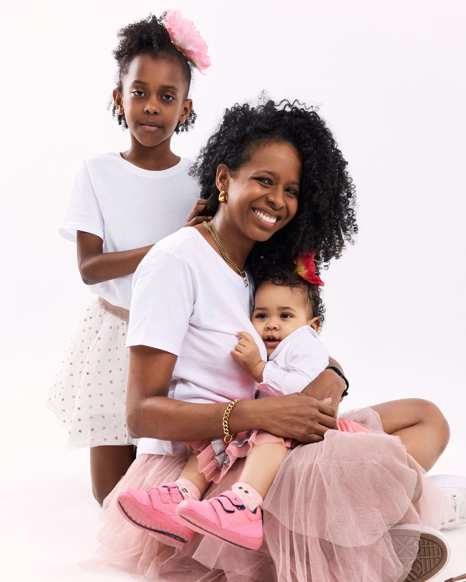 Sweet moment captured between two people wearing pink and white outfits in a studio setting.
